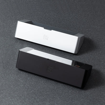 Bliss Artisan Tray shown in Black and Silver finishes — 24-slot keycap display case with tempered glass lid